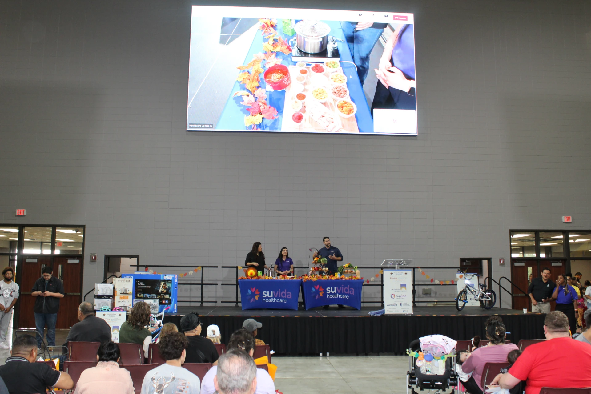 Cooking demonstration taking place on stage with a large screen display and seated audience during the Equality Health Foundation Houston Fall Festival 2026